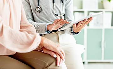 Ärztin hält die Hand einer Patientin
